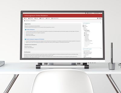 Auf einem Schreibtisch steht ein großer Computerbildschirm, der den Moodle-Kurs der Online-Redaktion anzeigt. anzeigt. 